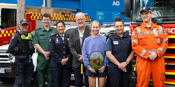 Seven people are standing in front of a variety of first respo<em></em>nders and emergency vehicles.